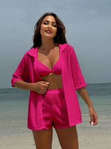 Detailed macro shot of bright pink mesh knit cardigan over a bikini beach ensemble