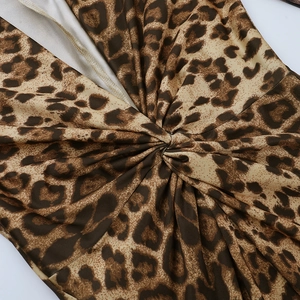 Dettaglio del design con nodo a torsione e stampa leopardata sull'abito a maniche lunghe