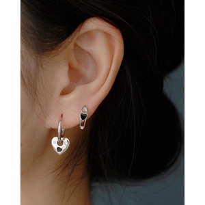 Detail of 925 silver heart stud earrings with black drip oil and sparkling stones