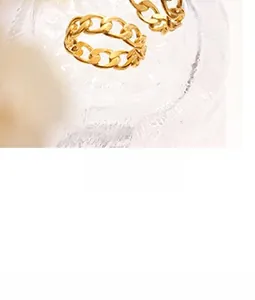 Detail of two golden Cuban link rings showing polished texture on glass rim