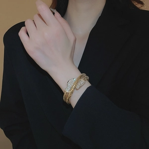 Detailed macro view of gold-plated coiled snake bracelet with shimmering rhinestones