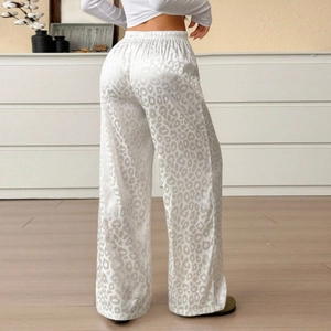 Detail of high waist elastic band on white leopard print satin wide leg trousers