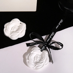 Scented camellia plaster tablets with black ribbons in a modern aesthetic composition