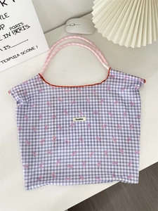 Close-up of purple plaid tote bag with pink bows and a Sozakka brand label detail