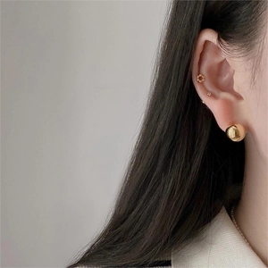 Detailed view of a gold ball stud earring set featuring various spherical and floral shapes