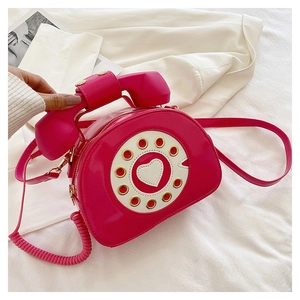Top-down view of creative rose red telephone-shaped patent leather crossbody bag