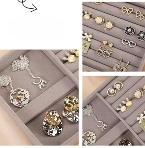 Macro detail of gray velvet jewelry tray with slots for earrings and pearl rings