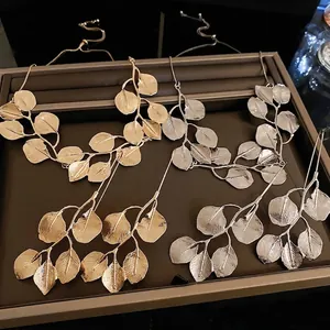 Exaggerated metal leaf branch statement necklace set in polished gold and silver tones