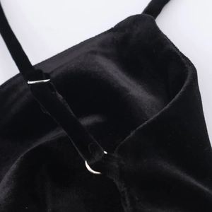 Détail des boucles en métal réglables sur les bretelles en velours noir de la robe