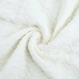 Macro shot of white textured seersucker fabric with ruffle details and spiral wrinkles
