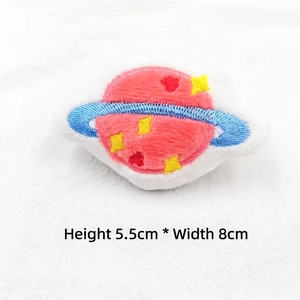Detail of pink embroidered Saturn plush pin with star and heart patterns, 8x5.5cm size
