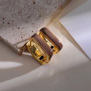 Macro shot of gold-plated square hoop earrings with brown enamel finish on stone