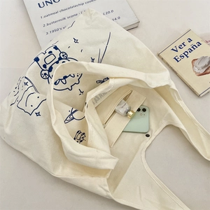 Detail view of canvas tote bag showing inner zipper pocket with a smartphone inside