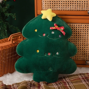 Close-up of green plush Christmas tree pillow with yellow star and red bow details