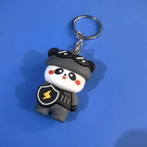 Close-up of cute silicone panda keychain in tactical suit with silver metal keyring