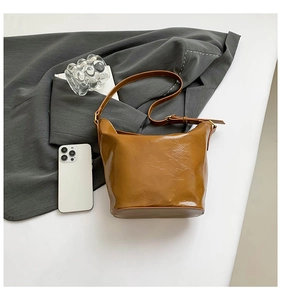 Detailed texture of vintage caramel brown leather bucket bag with oily wax finish