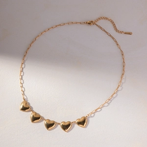 Detailed close-up of golden S925 heart pendant necklace showing lobster clasp and stamps