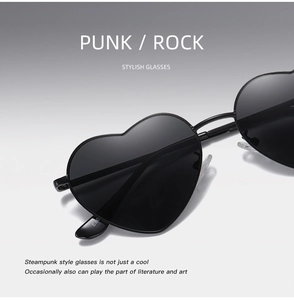 Detail view of black heart-shaped punk sunglasses with metal frames and spring hinges