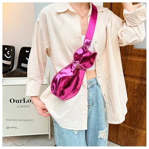 Metallic magenta cat-shaped crossbody bag shown in detail on a street style model