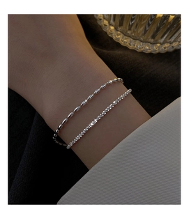 Detail of silver double-layered bracelet with shimmering zircon stones on a female wrist