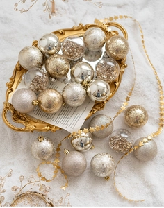 Detailed view of assorted gold and silver Christmas ball ornaments on a vintage tray