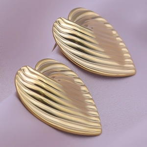 Macro shot of 18K gold plated heart earrings with textured rib pattern on purple fabric