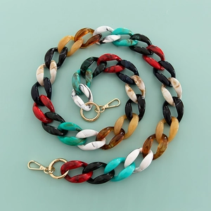 Detailed macro view of colorful acrylic chain links with gold metal lobster clasps