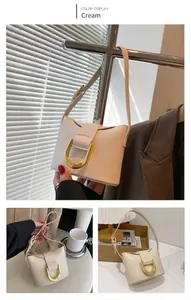 Detail of cream white PU leather shoulder bag featuring a gold horseshoe metal buckle