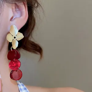 Elegant floral gold stud earrings with deep red acrylic drop pendants for women
