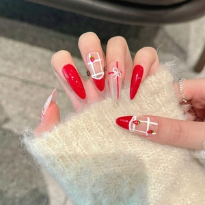 Sweet red and white almond press-on nails with strawberry art and 3D bows on a soft sweater
