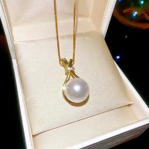 Goldene Perlenkette mit Zirkonia-Anhänger in einer beigen Schmuckschatulle präsentiert