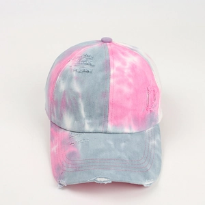 Detail view of pink and blue tie-dye pattern on distressed cotton baseball cap texture