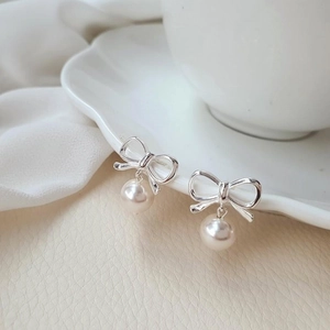 Élégantes boucles d'oreilles en argent 925 avec nœud et perles sur plat en céramique