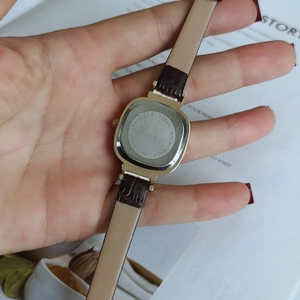 Detail of square quartz watch back with stainless steel cover and brown leather strap