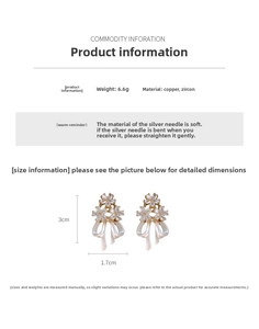 Détail macro de boucles d'oreilles fleur et nœud plaquées or avec zircons