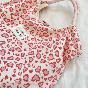 Détail du sac en toile à imprimé léopard cœur avec poignée en corde tressée arc-en-ciel