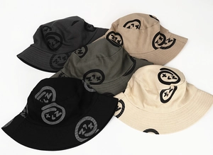 Flat lay of cotton bucket hats featuring graffiti smiley face patterns in five colors