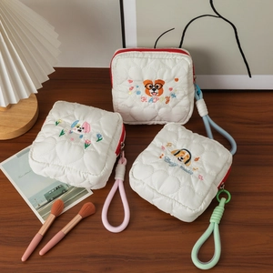 Détails de broderie chien sur l'ensemble de trousses cosmétiques blanches matelassées