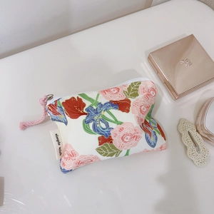 Detail view of pink floral cotton mini pouch with zipper and simple wish label