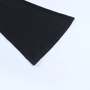 Détail de poignets évasés avec dentelle sur combinaison noire ajustée et texture maille