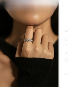 Detailed view of S925 sterling silver hollow heart ring with pavé diamonds on finger