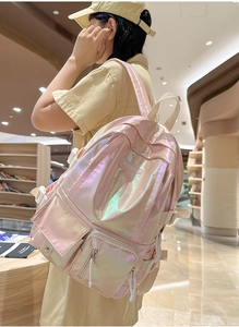 Detail of pink holographic backpack with multiple pockets in a library setting
