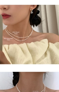 Detail of layered freshwater pearl necklace and gold bow earrings on a model
