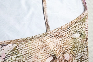 Macro detail of snake print fabric showing high elasticity stitching and thin straps