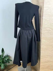 Rear view of black long-sleeve knit top and matching flared midi skirt set with textured fabric