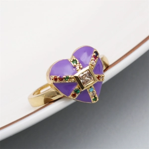Close-up of golden adjustable heart ring with purple enamel and colorful zircon stones