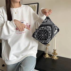 Detail of the black paisley floral makeup bag with a branded Sadio woven label