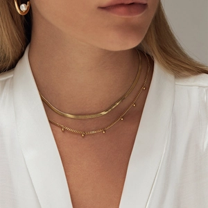 Detail of layered 18K gold-plated stainless steel snake chain and bead necklace set