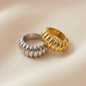 Macro shot of gold and silver croissant style stainless steel rings with ribbed texture