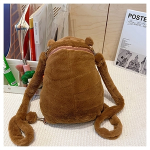 Detailed view of brown plush capybara backpack with adjustable straps on a desk